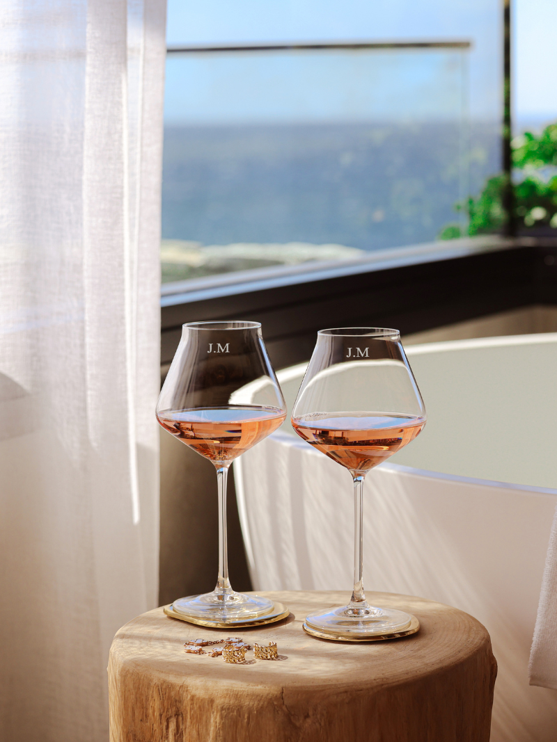 ersonalized corporate gifts wine glasses with initials and gold jewelry on wooden stool
