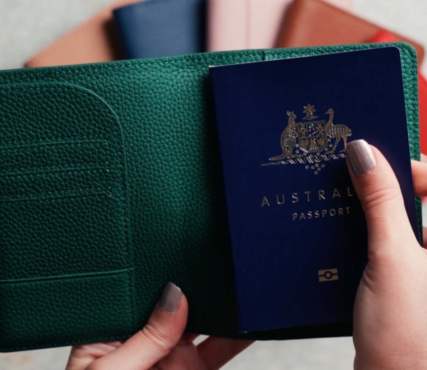 Hands holding a green Mont Laurént passport holder with an Australian passport tucked securely inside